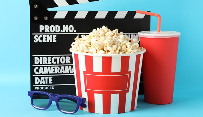 Buckets of popcorn with a movie real and "cut" board