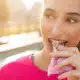 Woman in a bright pink shirt eating a snack bar