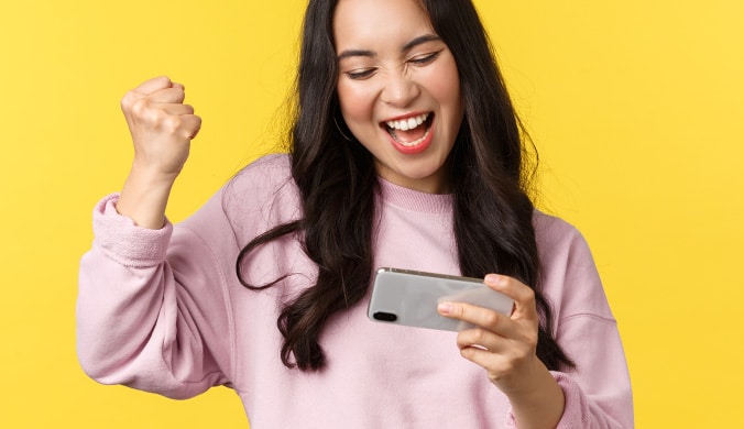 Woman celebrating a win while playing mobile game