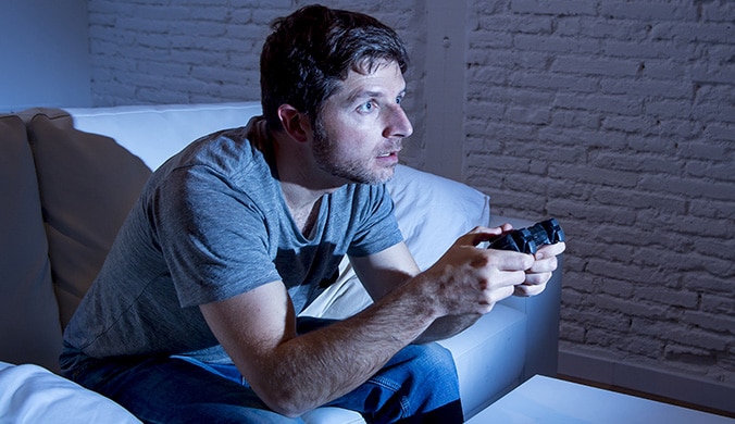 a man intensely playing a video game in his living room.