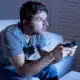a man intensely playing a video game in his living room.