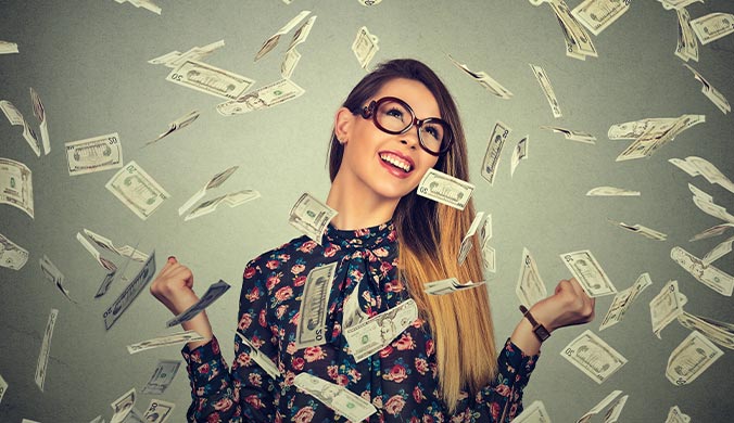 attractive young woman ecstatic over receiving a Red Stag 100 free spins shown by money cascading down all around her