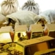 A photo of gold bars, gold coins and bags stuffed with coins spread over a surface with a white background
