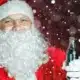 An image of a man dressed as Santa holding a dark beverage in a glass bottle surrounded by snowflakes - Everygame Red