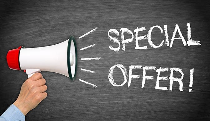A man holding a loudspeaker against a blackboard with the text special offer written in white chalk no deposit bonus deals