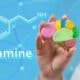 An image of a female doctor holding a colorful plastic brain with the word dopamine in white on a blue background