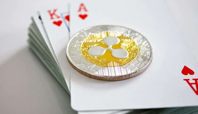 An illustration of an XRP token lying on a deck of cards on a light surface